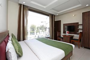 a bedroom with a bed and a desk and a window at Hotel Sea in Patiāla