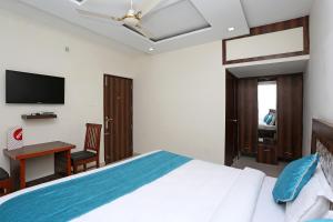 a bedroom with a bed and a desk and a television at Hotel Sea in Patiāla