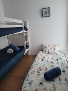 a bedroom with a bunk bed and a bedsheet with boats on it at Au Petit Brick - Cosy beachfront house in Maupertus-sur-Mer