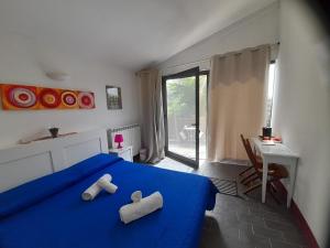 a bedroom with a blue bed with two pillows on it at Il Sentiero in Acquapendente