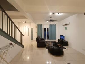 a living room with a couch and a television at Elvy Homestay Alam Sutera Puncak Alam in Bandar Puncak Alam