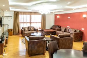 a living room with leather furniture and a table at The Ole-Ken Hotel in Nakuru