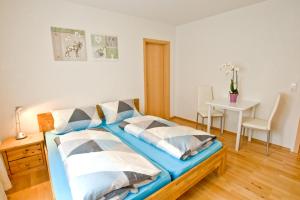 a bedroom with a blue bed with pillows on it at Gasthof Hirsch in Waldstetten