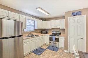 a kitchen with white cabinets and a stainless steel refrigerator at Welcoming Byrdstown Home Walk to Main St! in Byrdstown