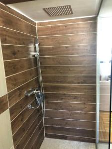 La salle de bains est pourvue d'une douche avec un mur en bois. dans l'établissement Apartments Villa More 3 Apartments 4-4-6 Beds, à Bobovišća