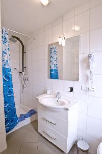 a white bathroom with a sink and a shower at Gasthof Hirsch in Waldstetten