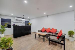 a living room with a couch and red pillows at Townhouse 056 T Nagar Chennai Near AGS Cinemas T Nagar in Chennai