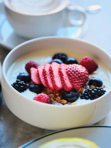 a bowl of yogurt with berries and granola at The Madrid EDITION in Madrid