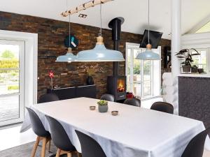 a dining room with a table and a fireplace at 6 person holiday home in Otterup in Otterup