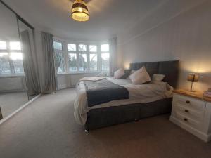a bedroom with a bed and a dresser and windows at Beach House, with BBQ lodge and Hot Tub! in Bournemouth