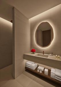 La salle de bains est pourvue d'un lavabo et d'un miroir. dans l'établissement The Madrid EDITION, à Madrid