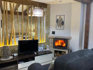a living room with a tv and a fireplace at Alojamiento Cerro Socorro in Cuenca
