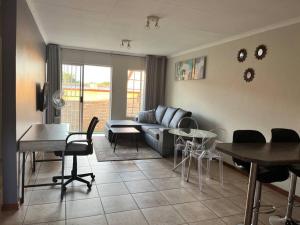 a living room with a couch and a table and chairs at The Reeds: 2 Bedroom townhouse in Centurion