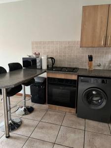 a kitchen with a stove and a washing machine at The Reeds: 2 Bedroom townhouse in Centurion