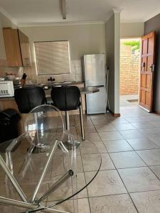 a kitchen with a table and chairs and a refrigerator at The Reeds: 2 Bedroom townhouse in Centurion