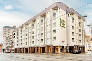 un grand bâtiment blanc sur le côté d'une rue dans l'établissement B&B Hotel Bremen-Altstadt, à Brême