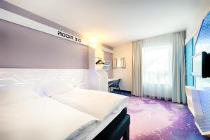 a hotel room with a bed and a tv at B&B Hotel Bremen-Altstadt in Bremen