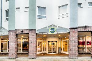 a facade of a building with a aaq store at B&B Hotel Bremen-Altstadt in Bremen