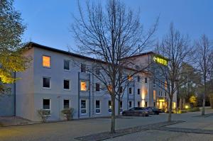 een wit gebouw met een bord dat het hotel leest bij B&B Hotel Düsseldorf-Ratingen in Ratingen