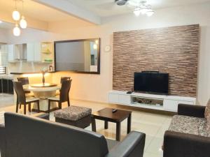 een woonkamer met een bank, een tafel en een televisie bij 49 Kulai Baiduri 4BR 11pax Double Storey Guared near JPO, Airport, AEON Kulai in Kulai