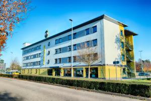 ein Gebäude an der Straßenseite in der Unterkunft B&B HOTEL Baden-Airpark in Rheinmunster