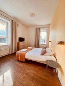 a bedroom with a large bed and two windows at Jugend Boutique Hotel in Pietarsaari