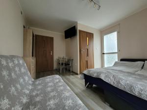 1 dormitorio con 1 cama, 1 silla y 1 mesa en Przy Deptaku, en Mielno