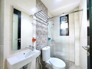 a bathroom with a white toilet and a sink at Shinta Guesthouse in Malang