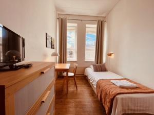 a hotel room with a bed and a desk with a television at Jugend Boutique Hotel in Pietarsaari