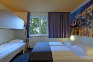 1 Schlafzimmer mit 2 Betten und einem Fenster in der Unterkunft B&B Hotel Frankfurt City-Ost in Frankfurt am Main