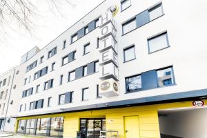 ボンにあるB&B Hotel Bonn-Westの黄色のドアと窓が特徴の白い大きな建物