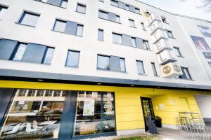 a building with a yellow and white facade at B&B Hotel Bonn-West in Bonn