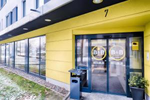 un edificio amarillo con una señal de seguridad en la puerta en B&B Hotel Bonn-West en Bonn