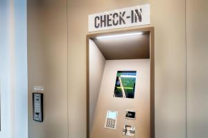 an elevator with a check in sign on the wall at B&B Hotel Bonn-West in Bonn
