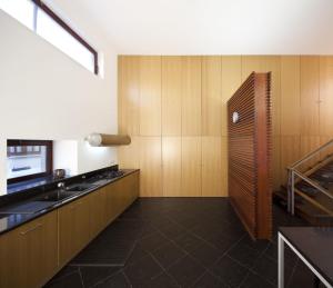 a kitchen with wooden cabinets and a sink and a stove at Seven Books House in Carrazeda de Anciães