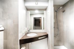 a bathroom with a sink and a shower at B&B Hotel Bielefeld-Ost in Bielefeld