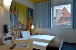 a hotel room with a bed and a window at B&B HOTEL Erfurt-Hbf in Erfurt