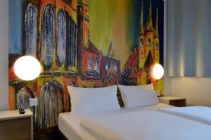 a bedroom with a bed with a painting on the wall at B&B HOTEL Erfurt-Hbf in Erfurt