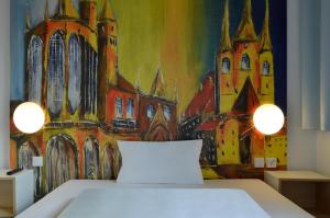 Schlafzimmer mit Wandgemälde in der Unterkunft B&B HOTEL Erfurt-Hbf in Erfurt