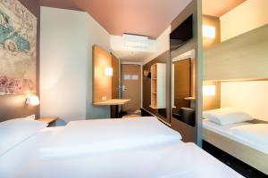 een hotelkamer met 2 bedden en een badkamer bij B&B Hotel Eisenach in Eisenach