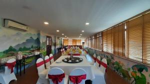 una sala da pranzo con tavoli bianchi e sedie rosse e bianche di Hoa Binh Hotel a Hòa Bình