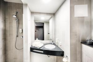 a bathroom with a sink and a shower at B&B Hotel Bochum-City in Bochum