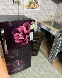 einen Kühlschrank mit einer Blume darauf neben einem Waschbecken in der Unterkunft John Beach House in Puducherry