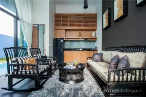Two Bedroom Wings Pool Villa في شاطئ بانغ تاو: غرفة معيشة مع أريكة وكراسي وطاولة