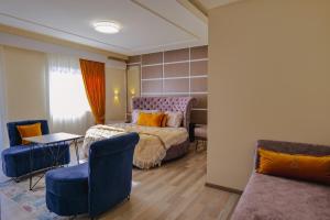 1 dormitorio con 1 cama, mesa y sillas en Hotel Number One, en Gjirokastra