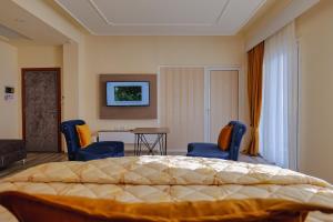 1 Schlafzimmer mit einem Bett, 2 Stühlen und einem Tisch in der Unterkunft Hotel Number One in Gjirokastër
