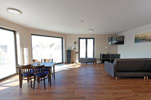 a living room with a table and chairs and a couch at Apartments Panoramablick in Mettlach