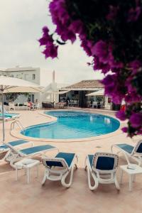 a pool with chaise lounge chairs and a swimming pool at Hotel d'Or in Cala d´Or