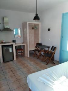 eine Küche und ein Wohnzimmer mit einem Tisch und Stühlen in der Unterkunft Amorgaia 2 in Katápola