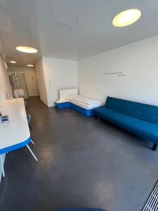 une salle d'hôpital avec un canapé bleu et une table dans l'établissement Chromotel self check-in, à Mezzovico
